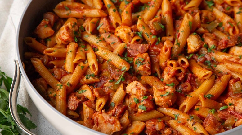 pasta with tomato sauce and parsley in a white pan