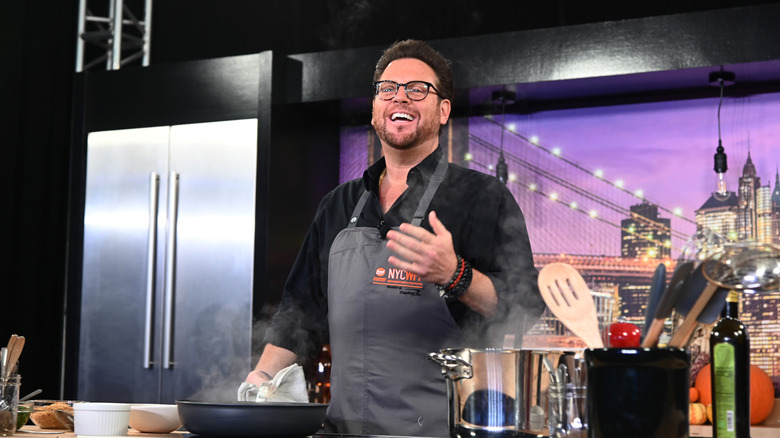 Scott Conant laughing on a kitchen show set