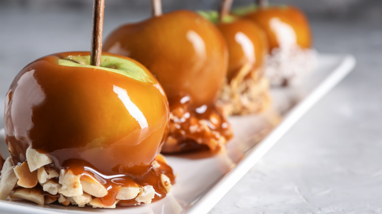 Four caramel apples with nuts