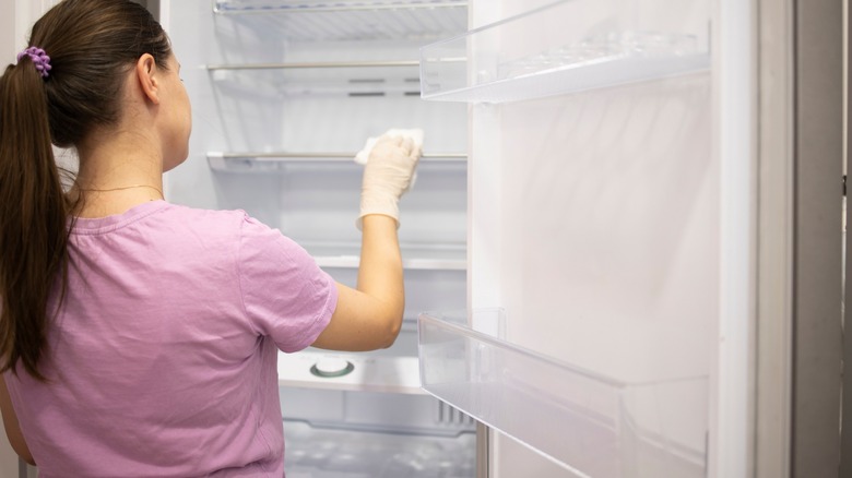 Woman cleaning fridge