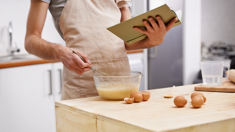 person reading cook book in kitchen