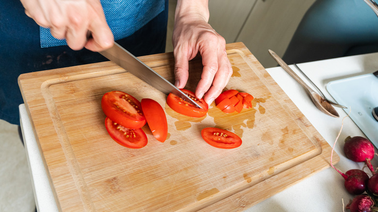 person cutting tomatoes with knife