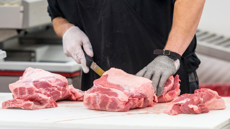 cutting raw meat on cutting board