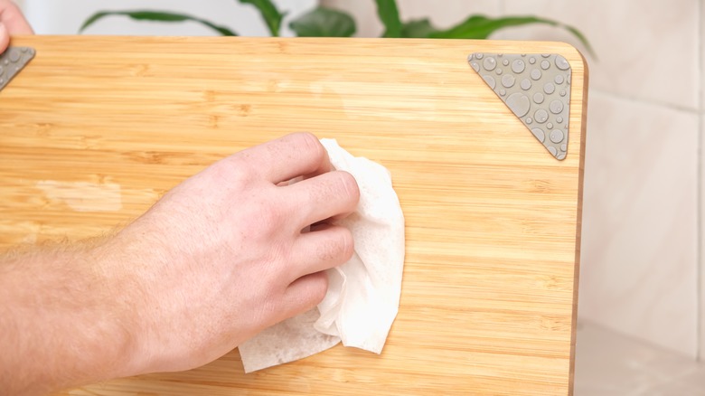 hand wiping cutting board