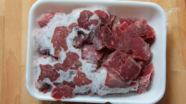 Meat defrosting on wooden counter