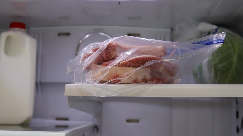 Frozen meat thawing in refrigerator