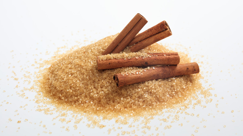 heap of sugar with cinnamon sticks