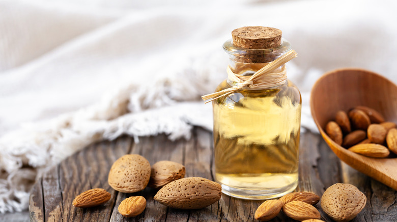 bottle of almond extract on table with almonds