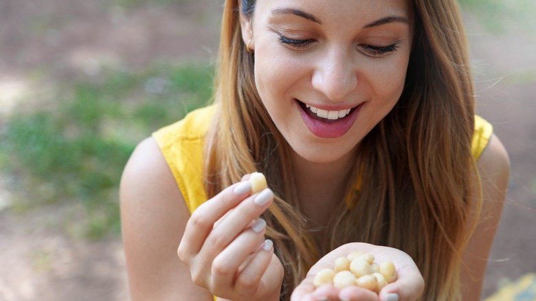 woman eating handful of nuts