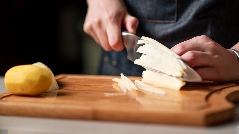 hands chopping potatoes