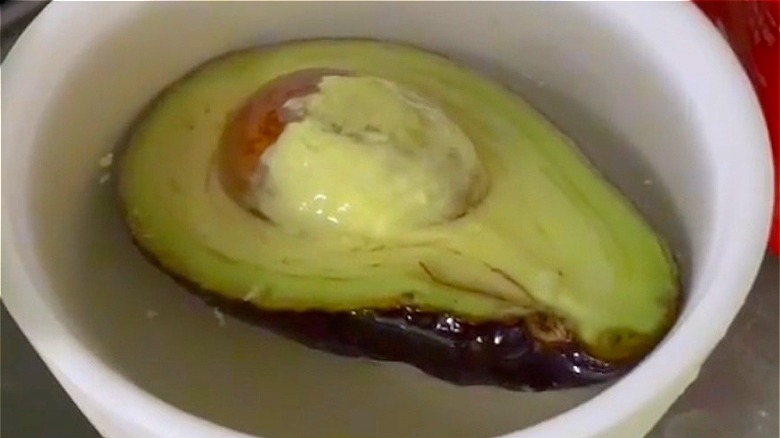 cut avocado submerged in water