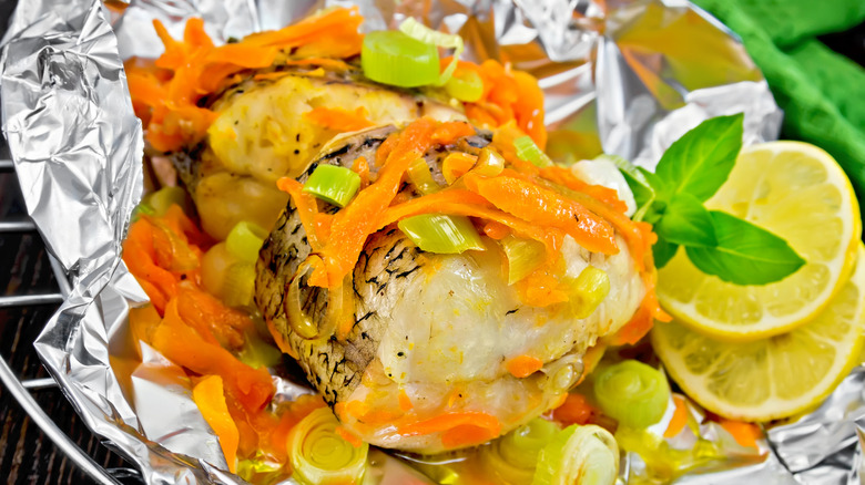 lemon slices and grilled fish in aluminum foil