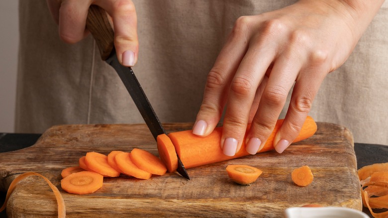 hands chopping carrots