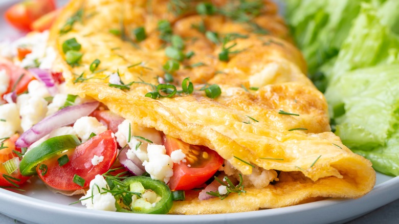 Omelet stuffed with onions, tomato, and peppers