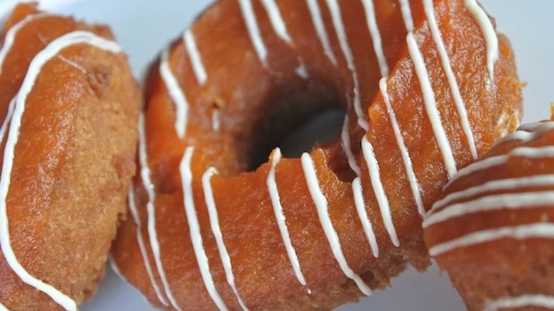 pumpkin donuts with white icing drizzle