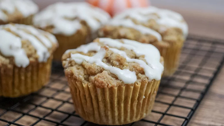 spooning icing on pumpkin streusel muffins