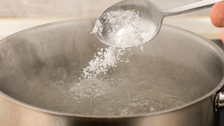 spooning salt into water