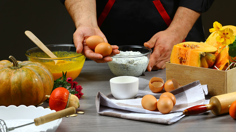 hand holding eggs for pumpkin pie