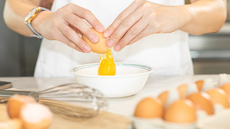 woman cracking egg into bowl