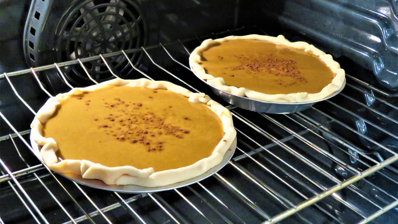 two pumpkin pies in oven