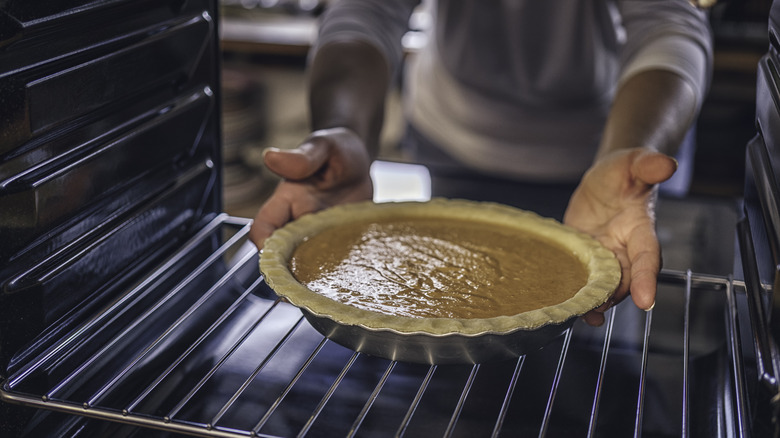 putting a pumpkin pie in oven