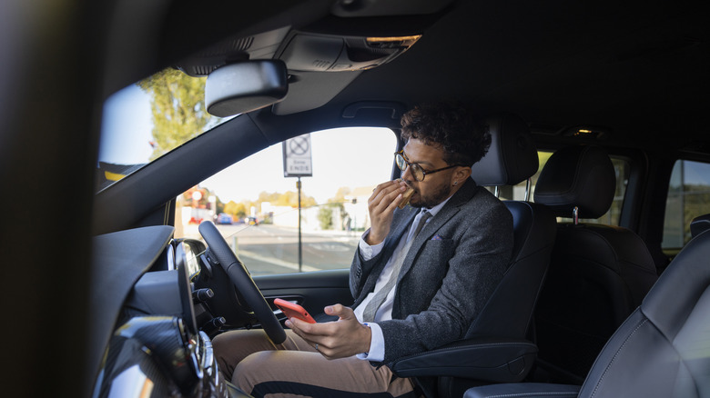 man eating in car