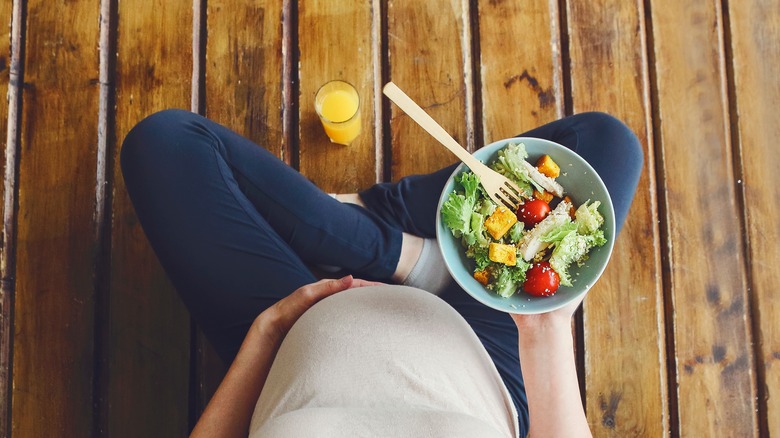 Pregnant woman with salad bowl 