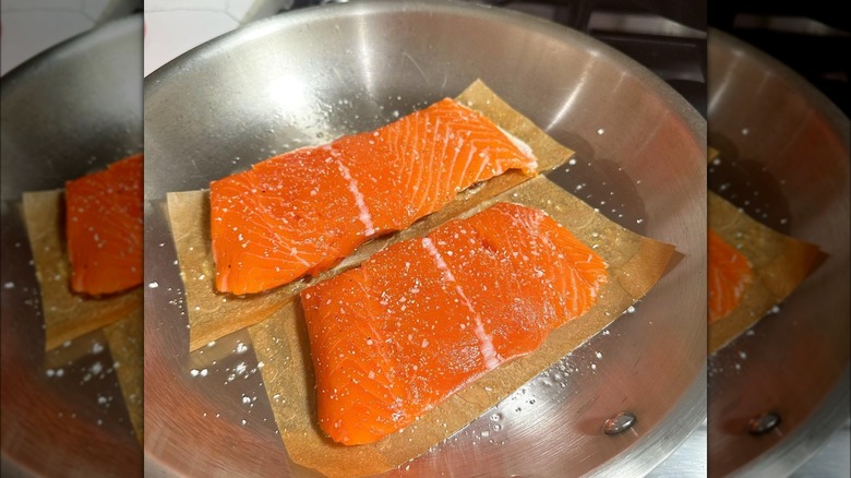 Salmon on parchment paper in pan