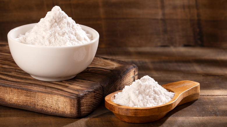 baking powder in white bowl and wooden spoon