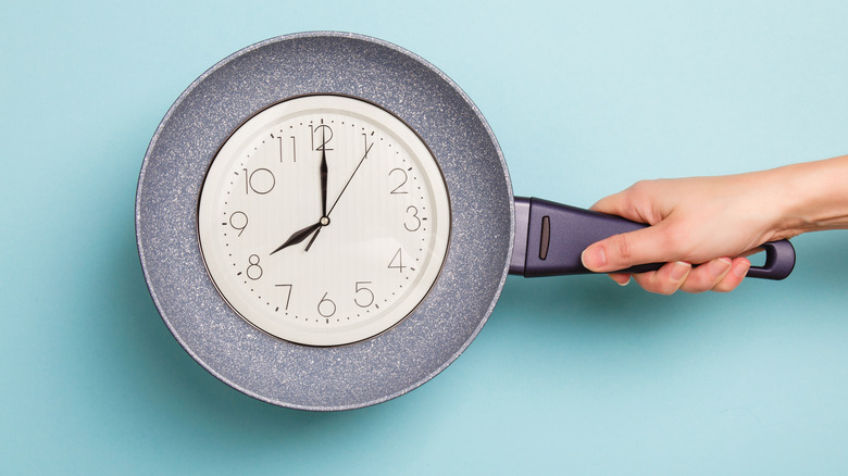 clock face on frying pan blue background