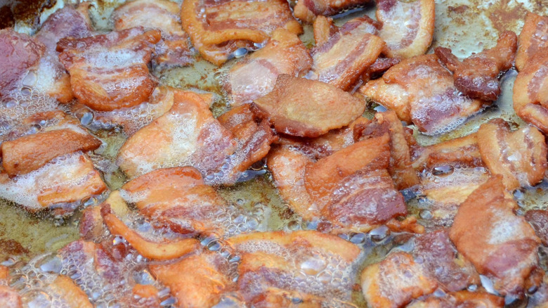 Bacon pieces frying in grease