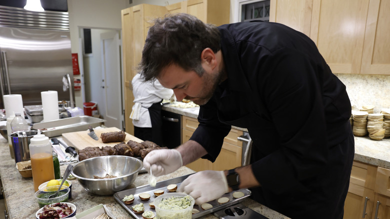 Top Chef host preparing dish in kitchen