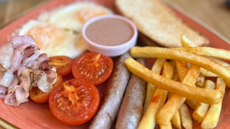 Fries, tomatoes and bacon on plate