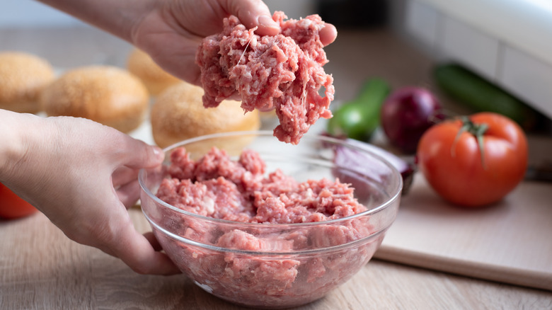 hands shaping ground beef patty