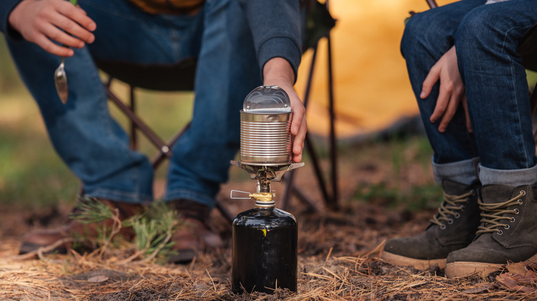 people cooking can while camping