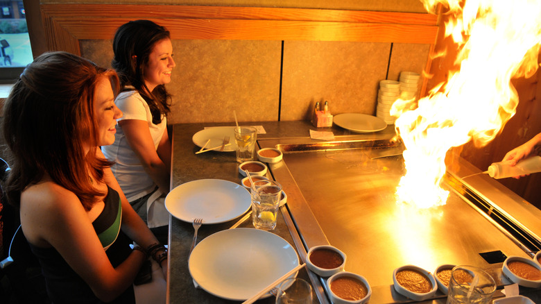 women watching hibachi flame