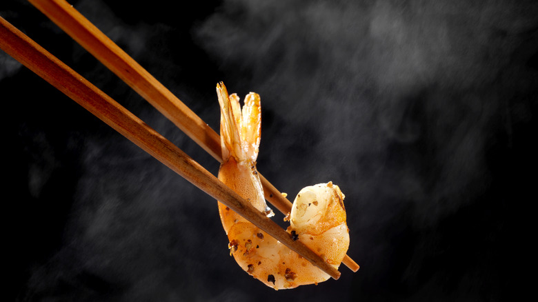 chopsticks holding hot shrimp