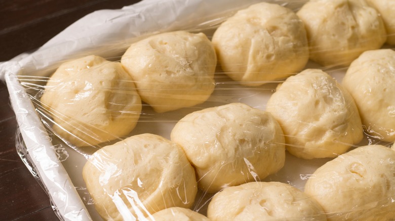 plastic-covered dough balls rising