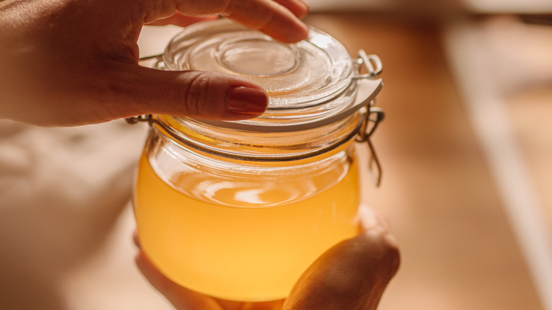 Person holding clarified butter jar