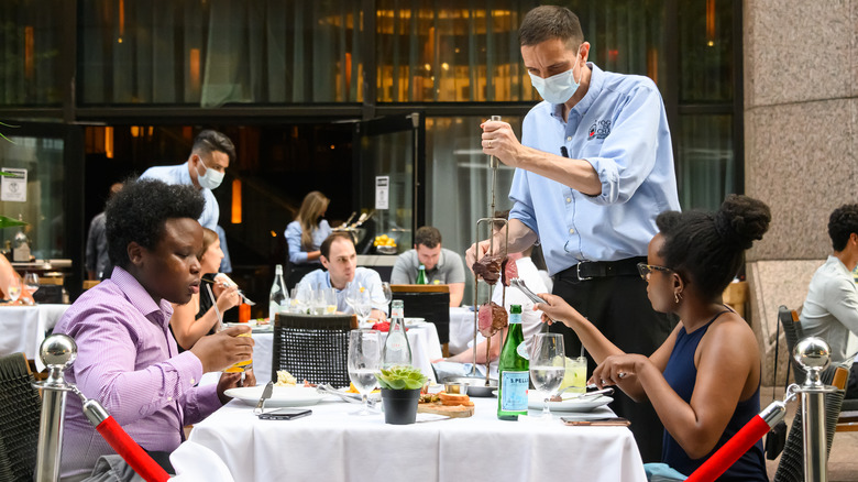 People dining at a Brazilian steakhouse