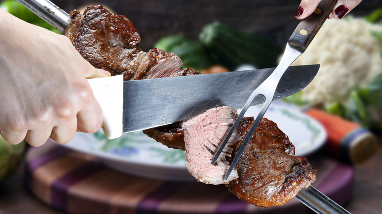 Steak rotisserie being cut into