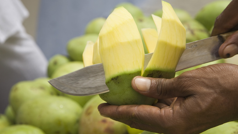 Man slicing green mango