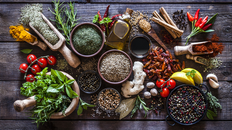 Fresh and dried herbs and spices wood background