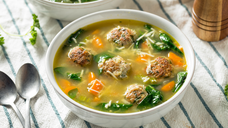 Italian meatball soup on table in white bowl