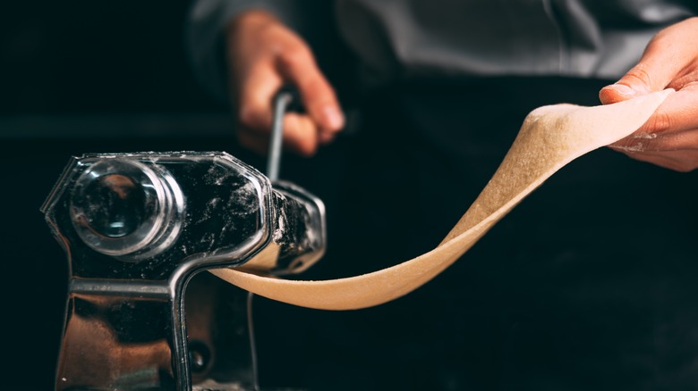 man turning pasta machine handle