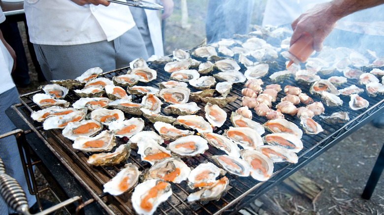 Adding sauce to grilling oysters