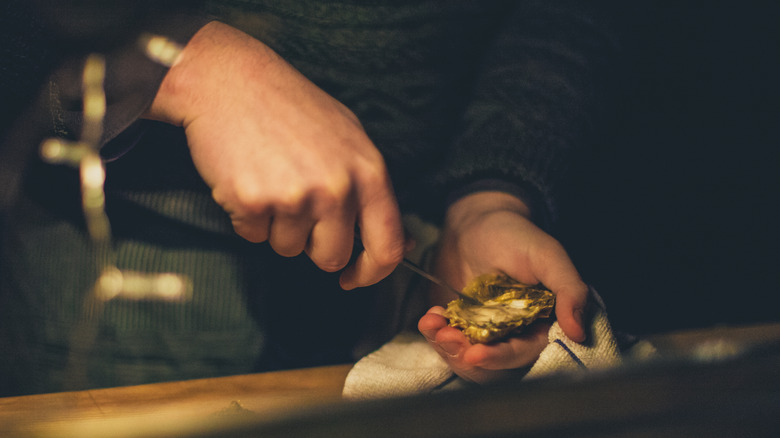 Person shucking an oyster