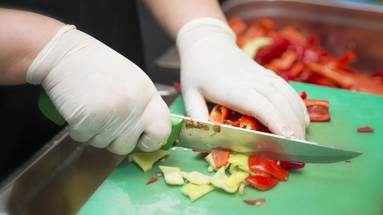 Person cutting peppers in gloves