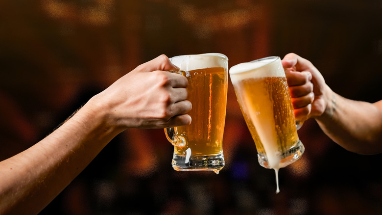 Men clinking mugs of beer together