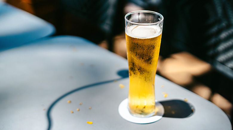 Glass of cold beer, sitting on an outdoor table